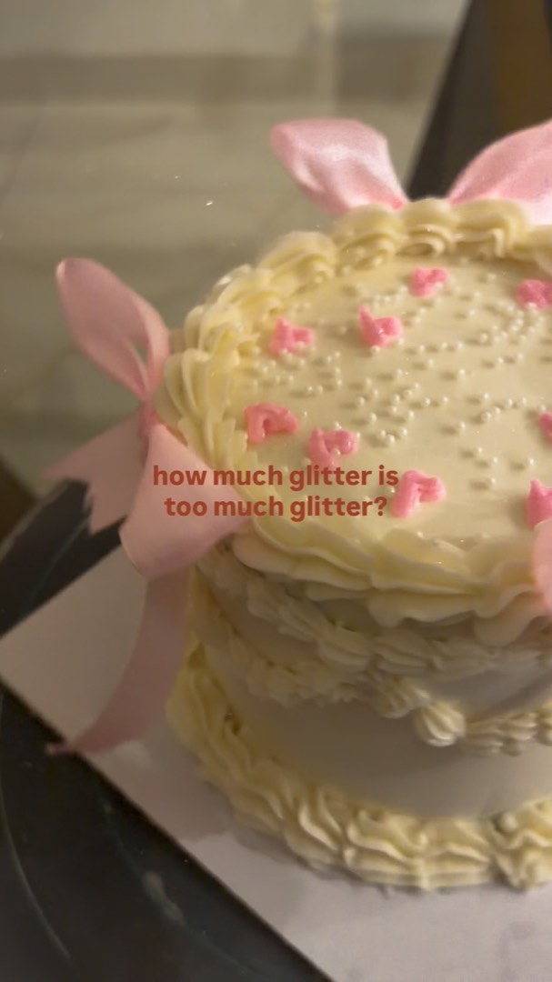 Pale cake covered in pink flowers and pearls
