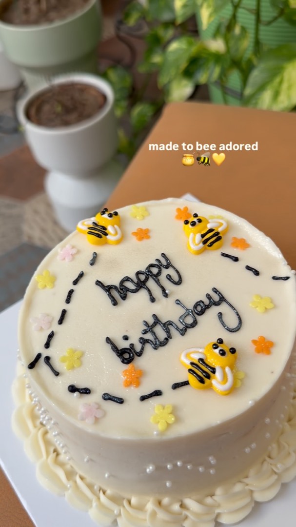 Buttercream birthday cake decorated with bees and flowers