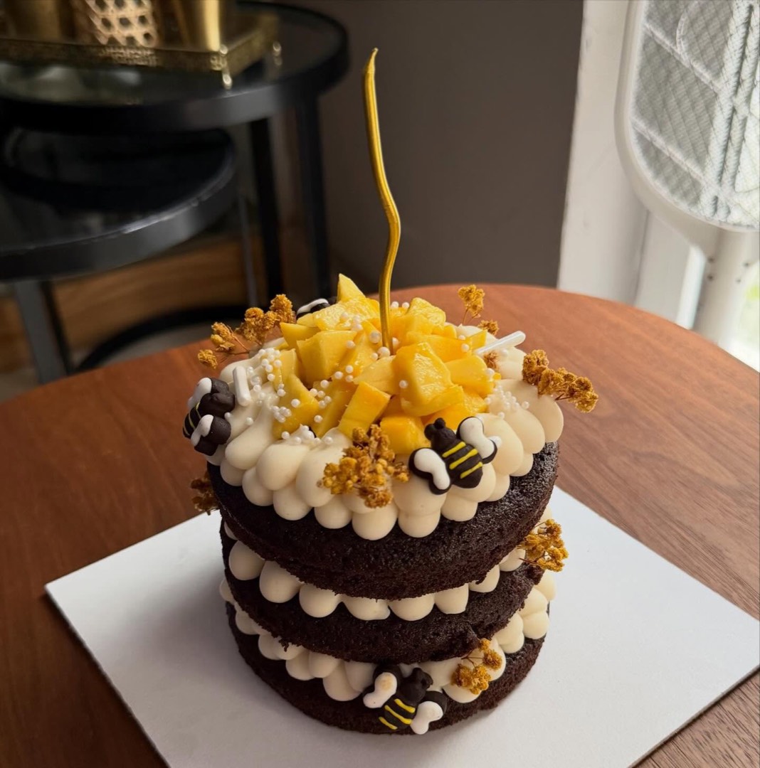 A chocolate naked cake topped with fresh mango